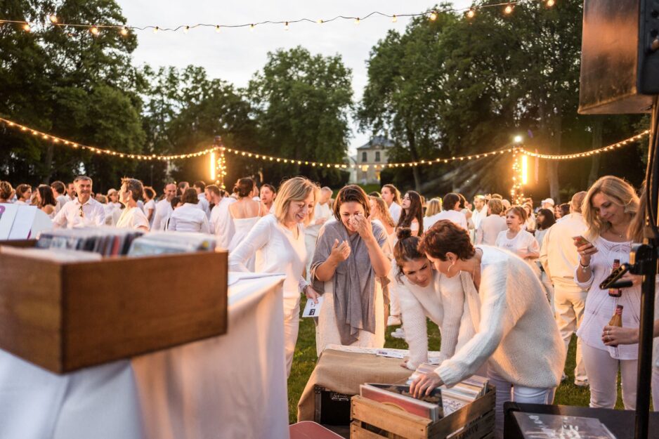 Personnes choisissant un vinyles lors du pique-nique blanc